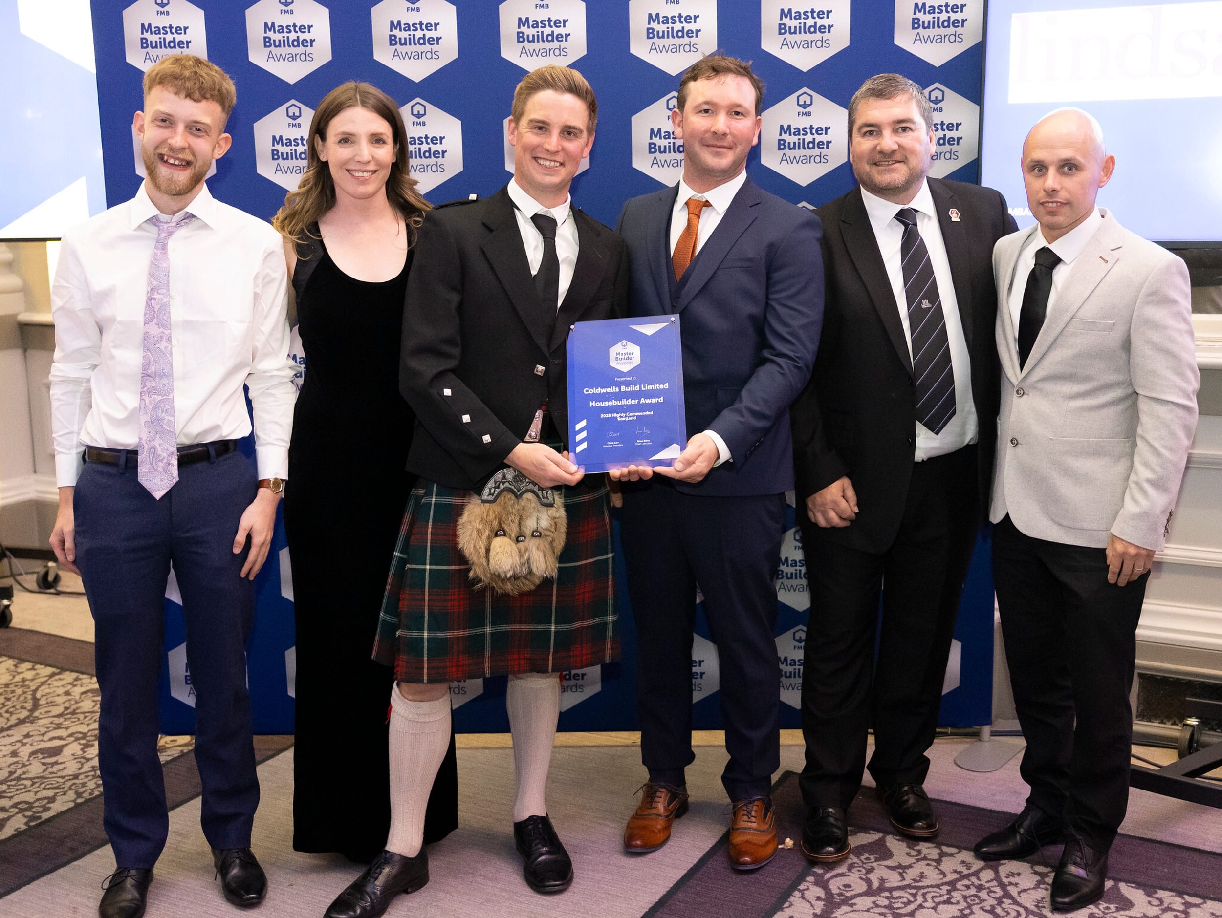 Coldwells Build team collecting a certificate at Federation of Master Builds Awards 2025.