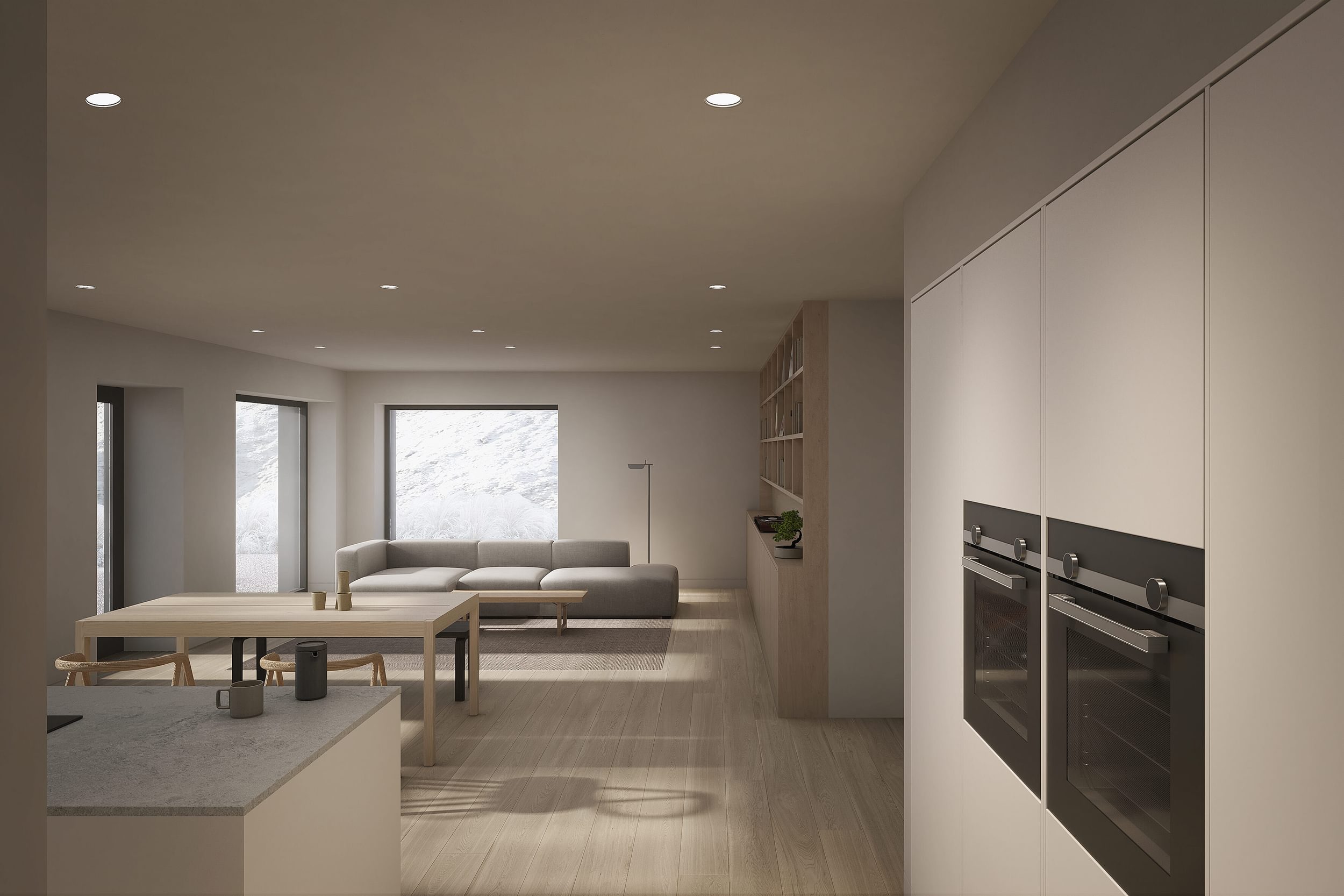 The interior living space and kitchen of the Coldwells Build Passivhaus, Anderson. Grey corner sofa, white open plan kitchen, bespoke fitted cabinetry and large windows.
