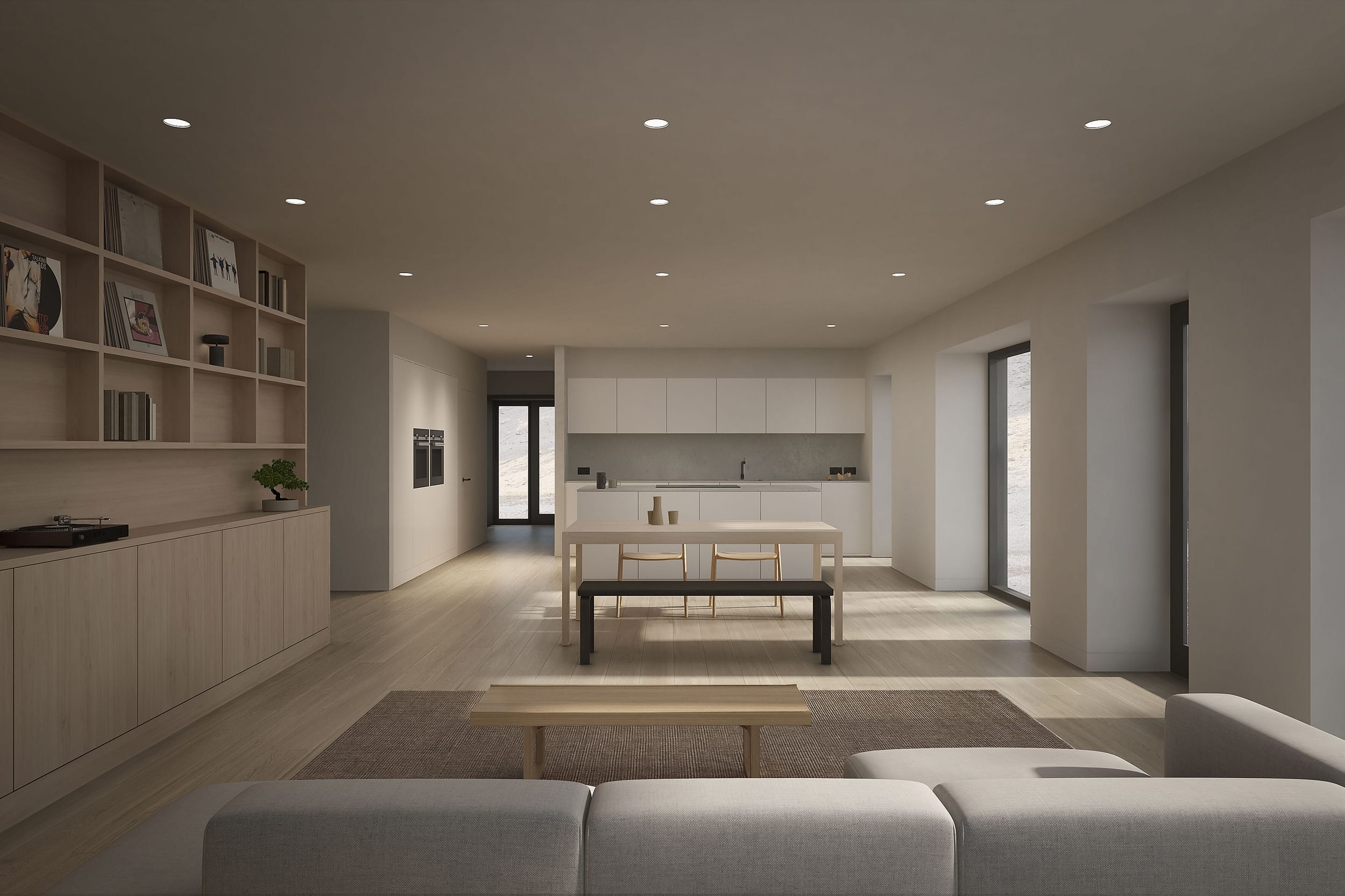 The interior living space and kitchen of the Coldwells Build Passivhaus, Anderson. Grey corner sofa, white open plan kitchen, bespoke fitted cabinetry and large windows.
