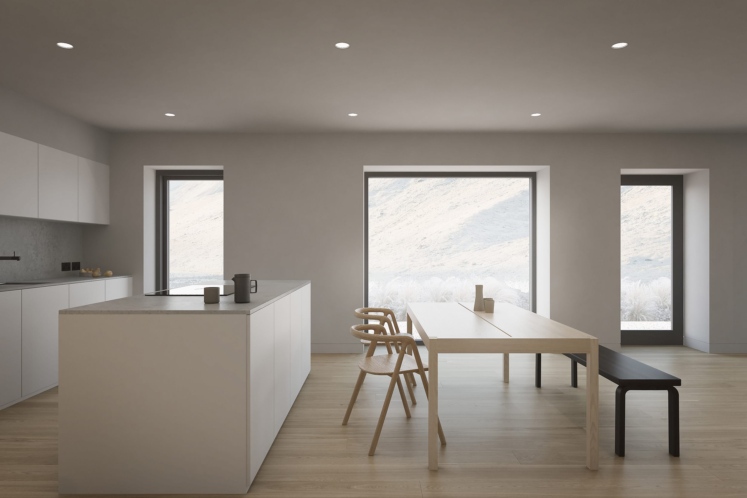 The kitchen of the Coldwells Build Passivhaus, Anderson. White open plan kitchen with island, large windows and dining table with chairs and bench.