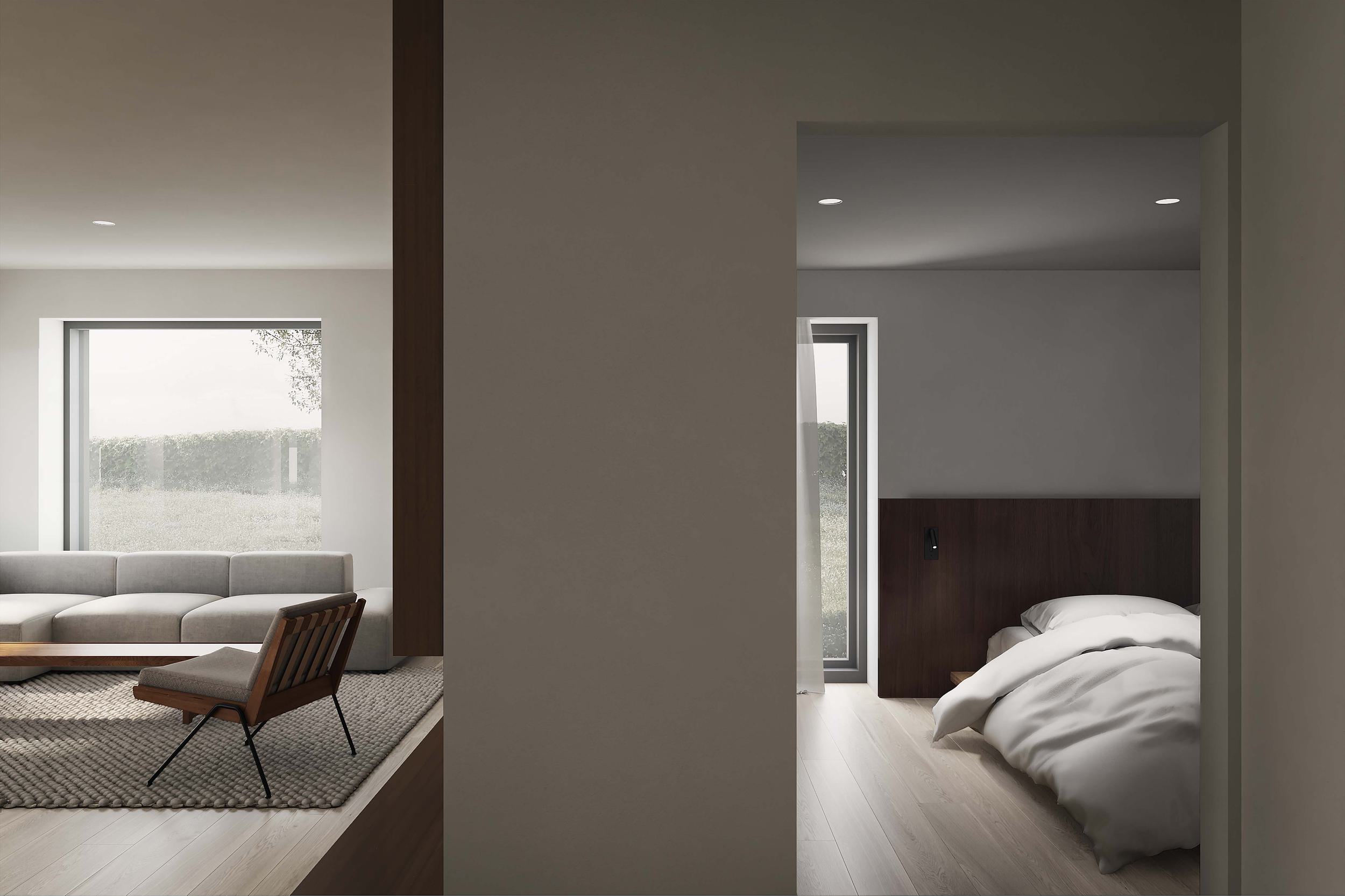 The interior living and bedroom space of the Coldwells Build Passivhaus, Argyle. Grey corner sofa, walnut headboard and bed and large windows.