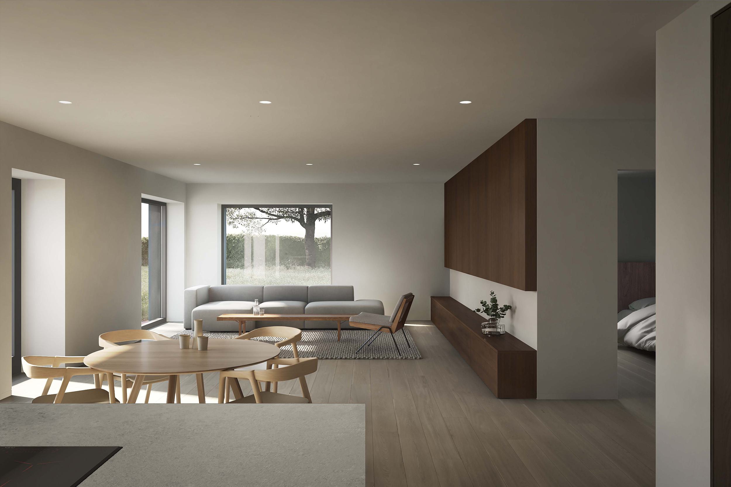 The interior living space of the Coldwells Build Passivhaus, Argyle. Grey corner sofa and an oak circular dining table and large windows.