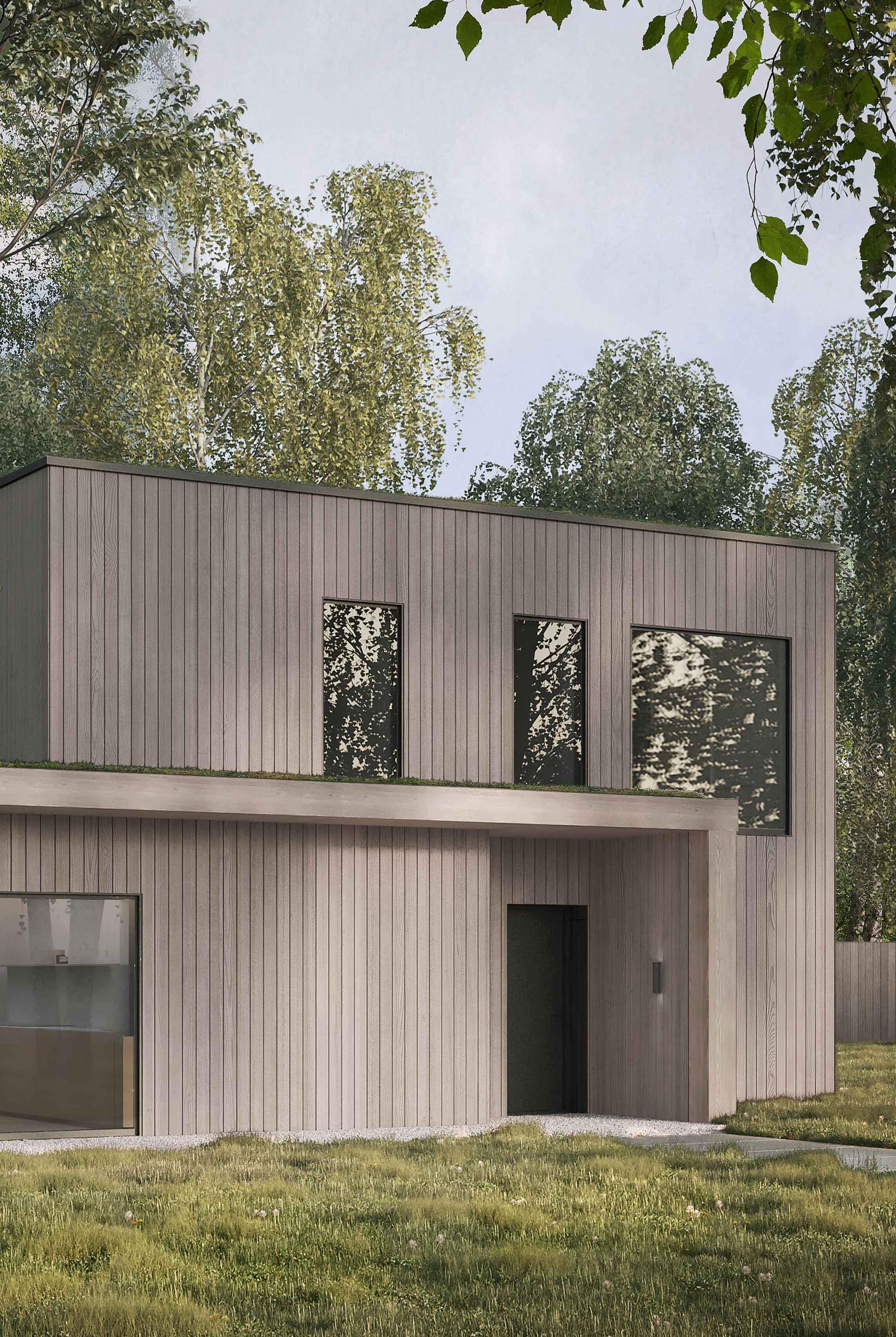 Exterior of the Coldwells Build Passivhaus, Foster. Oak cladding with a sedum roof in a forest setting.